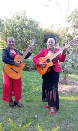 Dos músicas con guitarras en el jardín