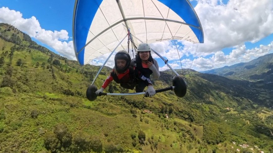 Piloto y pasajera en ala delta sobre las montañas verdes de Barbosa